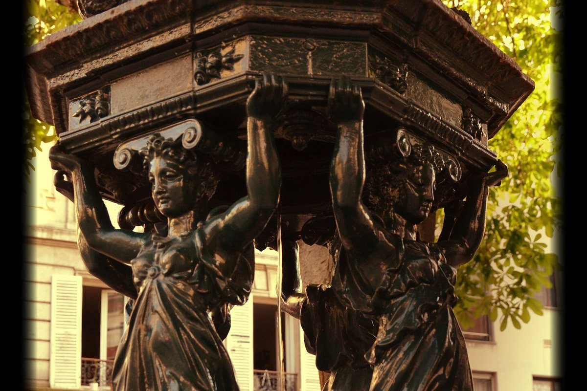 Fontaine Wallace en fonte verte dans une rue de Paris